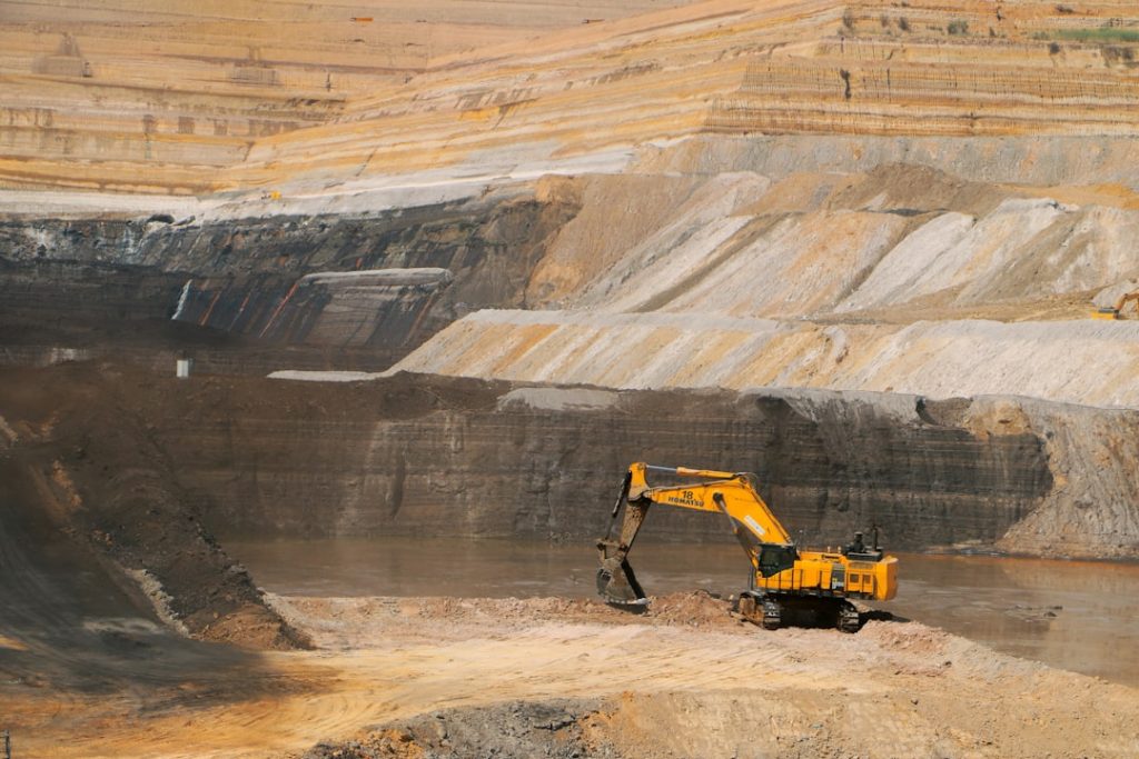 a-yellow-excavator-in-a-large-open-pit-1o-hnwey0o4