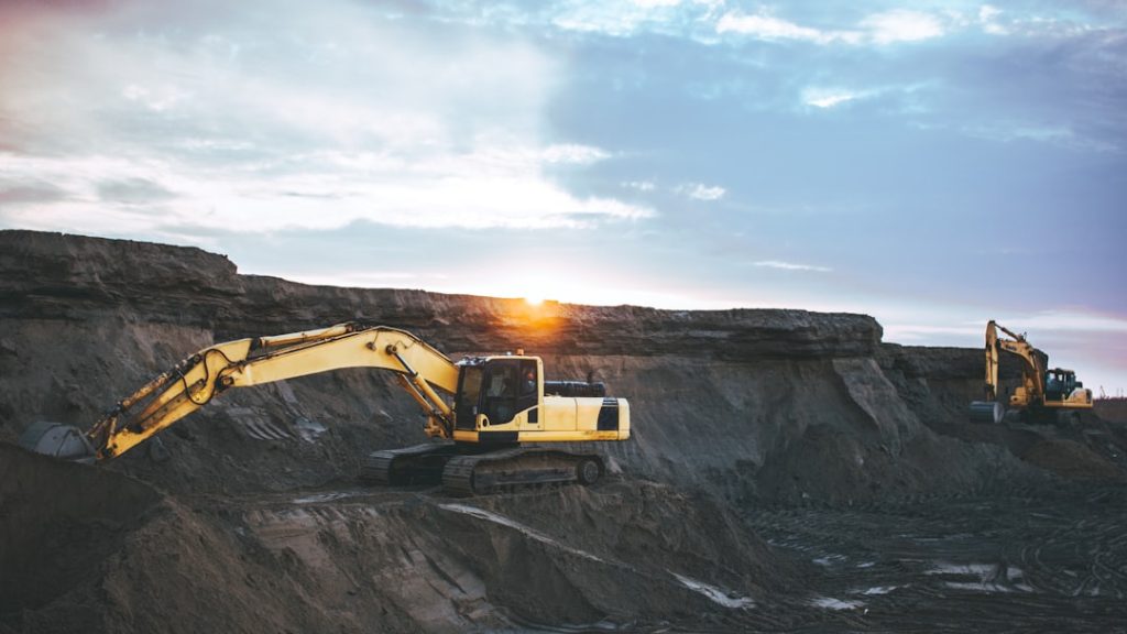 yellow-and-white-excavator-on-rocky-mountain-during-daytime-nwbyxwvn-j0
